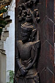 Old Bagan Myanmar. The Nat Taung monastery complex. High relief carved wooden pivot doors with dancing devas carrying floral sprigs.